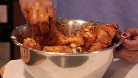 Slow motion video of Chicken being marinated with yogurt, herbs and spices for making Tandoori Chicken