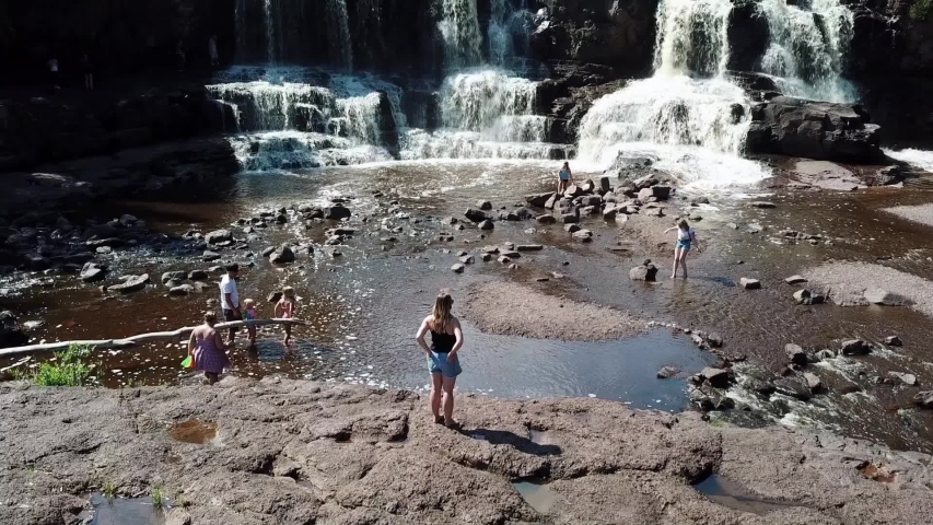 Family spending vacation time at the Gooseberry Falls in Minnesota waterfall, USA