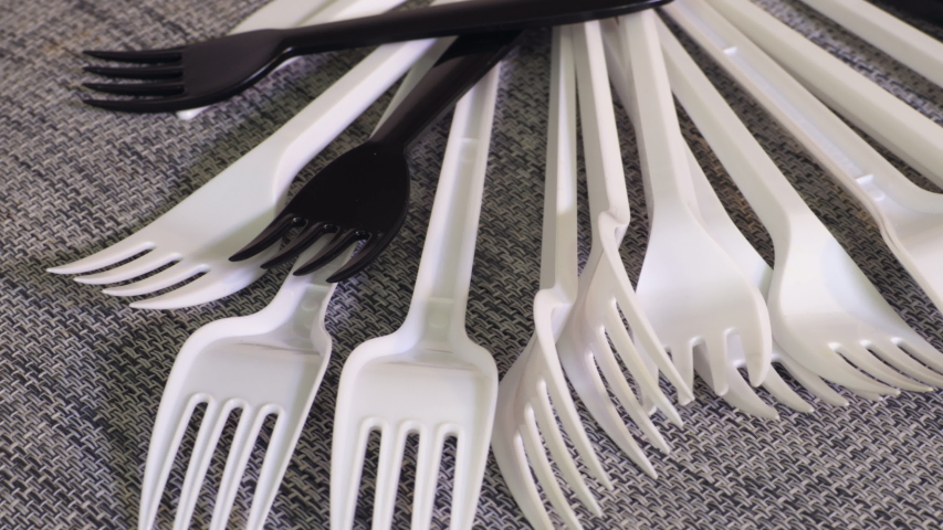 Rotating white and black plastic forks close up