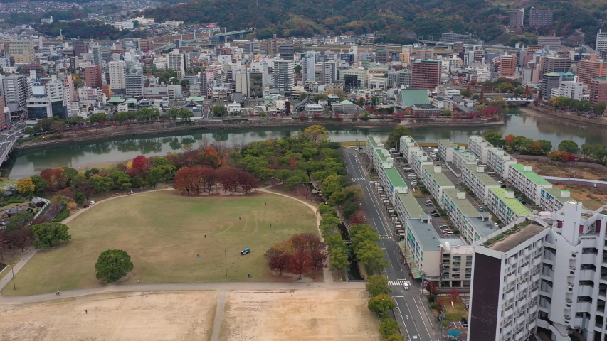Aerial view of Central Park in Hiroshima, modern Japanese city with disastrous history, picturesque autumn scenery with colorful trees - landscape panorama of Japan from above, Asia