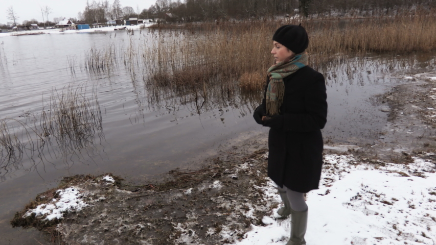 Woman at shore of the lake try to feed ducks
