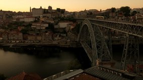 Wide clip of tram, cars and pedestrians cross the Ponte Luis in Porto at sunset. Taken on a late spring evening