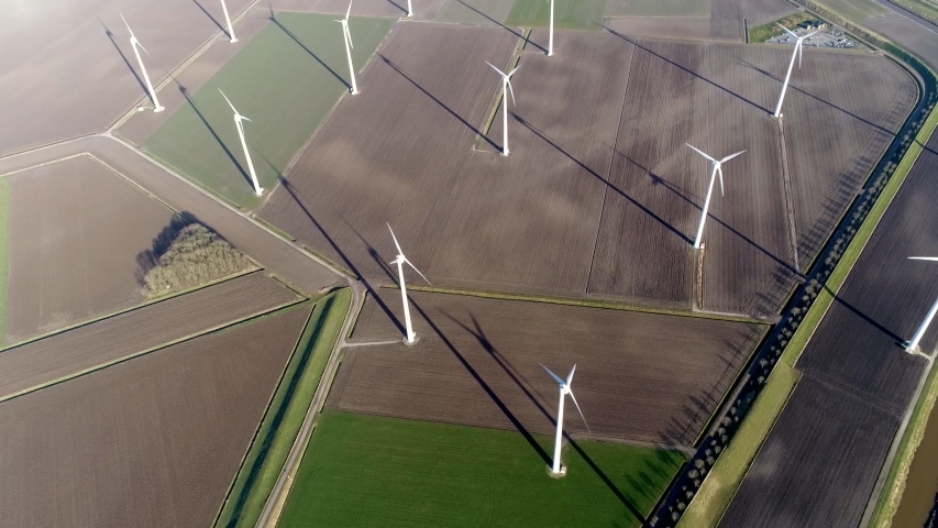Aerial top down footage of wind farm a group of windturbines in the same location used to produce electricity pruducing sustainable renewable energy provided by national recources 4k quality media Royalty-Free Stock Footage #1042552309