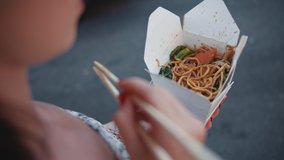 Young girl eating chinese noodles close-up
