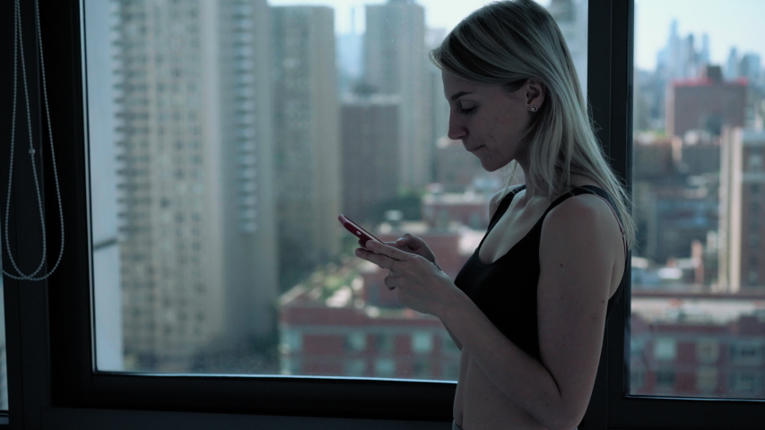 Caucasian woman drinking morning coffee during cellphone networking for browsing wireless website, millennial housekeeper using mobility searching for checking email message
