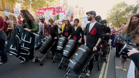 LONDON - SEPTEMBER 20, 2019: Extinction Rebellion protesters pushing black barrels in strollers at a march on Whitehall, London