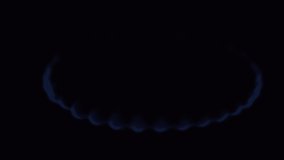 Gas blue flame. Gas stove on black background. Close-up of burning natural gas. Cooker. Fire on stove in dark on a kitchen. Switching on. Slow motion 4K UHD video