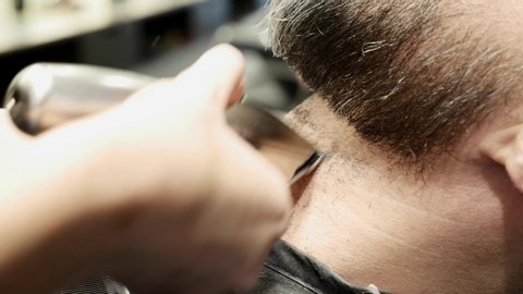 middle aged man being shaved at the barber shop or hairdresser, hipster style, beauty concept