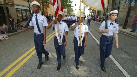 ORLANDO, FL circa November 2019 - Veterans Day Parade on the streets of Orlando. Includes audio. Young ROTC color guard marches down street with flags.