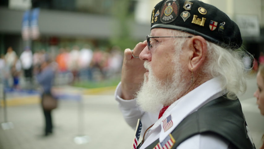 ORLANDO, FL circa November 2019 - Veterans Day Parade on the streets of Orlando. Includes audio. Vietnam veteran saluting the flag as it passes by.