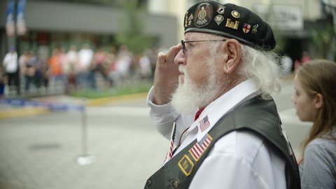 ORLANDO, FL circa November 2019 - Veterans Day Parade on the streets of Orlando. Includes audio. Vietnam veteran saluting the flag as it passes by.
