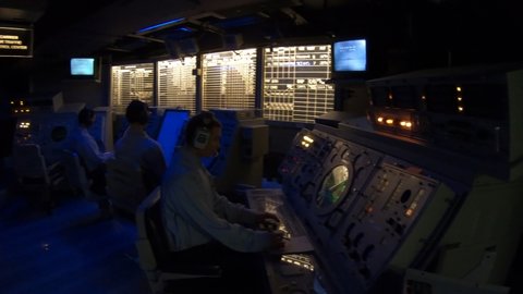 San Diego, Navy Pier, California, USA - JULY 31, 2018: soldier operators of detection and tracking room of the Battleship USS Midway at San Diego, Navy Historic museum. Dark mode with radar and sonar.
