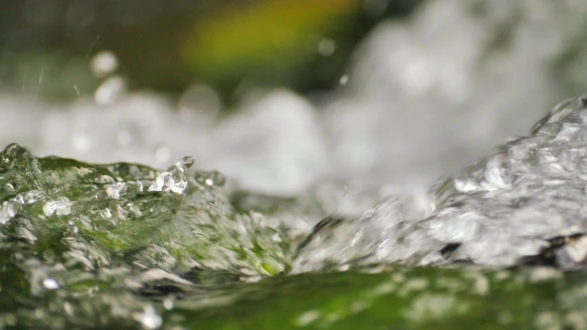 Pure mountain water flows over rocks covered with moss | Shutterstock HD Video #1042588672