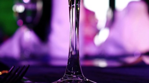 Glasses of Wine, champagne, soft-drink and soda  on Gala Dinner table with guests with moving light around. Gala Dinner and Party.