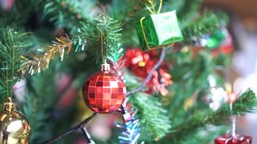 Red gold balls of Decorated Christmas tree and New Year holiday decoration on blurred background. de-focused lights with decorate trees. Winter season