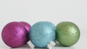Assorted colorful baubles on white background 4K video