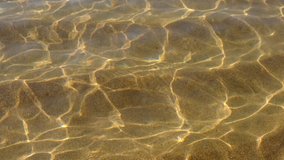 Sparkling sea water surface on sunny day at beach. Beautiful sun beams in ripple waves.
