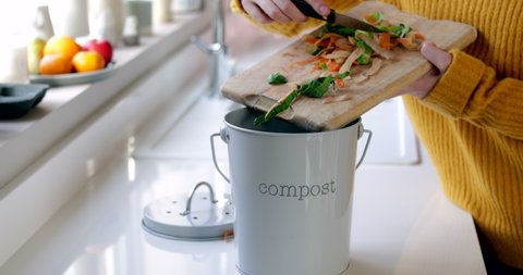 Close Up Of Woman Making Compost From Vegetable Leftovers In Kitchen