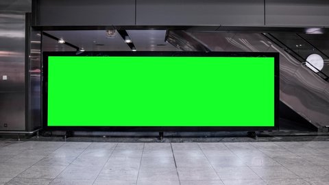 Empty blank widescreen billboard with green screen, alpha channel. Chroma key frame on airport hall, big banner for marketing. 