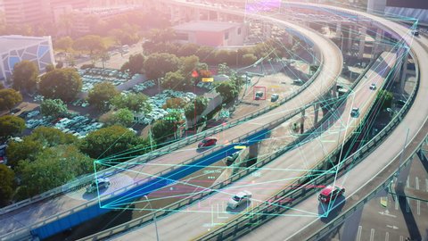 Beautiful aerial view of Self driving cars driving on a highway. Autonomous Autopilot cars self-driving on the highway aerial panorama of the road traffic in a big city on the sunset.
