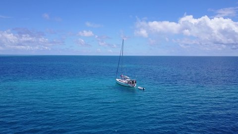 Wide Footage of a Sailing Boat in The Vast Blue Ocean With Cloudly Sky Above in New Caledonia - Wide View