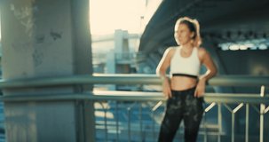 Portrait Young Sport Woman, close-up face girl running walking in the modern place in city in summer sunny day under sun light. 4K slow motion video
