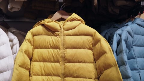 winter down jackets of different colors on the store shelf