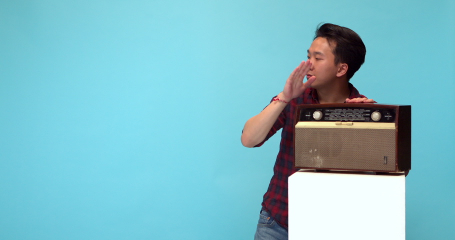 Studio, slow motion, young man clapping on a vintage radio