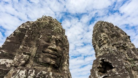 4K UHD Time lapse of Bayon temple stone head with cloud, blue sky in Angkor wat Angkor thom area. Prasat Bayon most  smiling stone faces on the many towers.