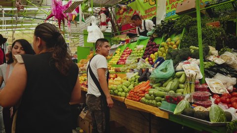 Mexico City , Mexico City / Mexico - 03 18 2019: Young man sells fruit at San Cosme Market