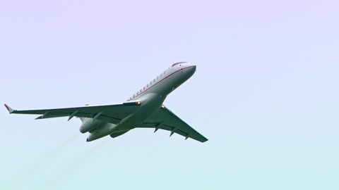Private business jet flying in the sky. No logos or markings. Isolated on the airplane as it flies over the camera.