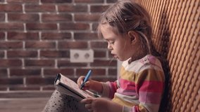 Happy little girl drawing with markers at home. Studio video shot of people in the action in 4K definition.