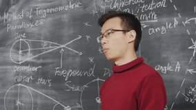 Lockdown of intelligent Asian student wearing eyeglasses presenting his project while standing at chalkboard - Powered by Shutterstock - Get 15% off with code: PIKWIZARD15
