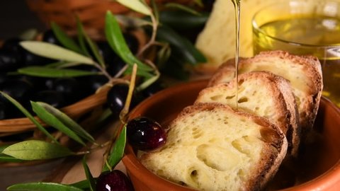 Genuine Italian organic oil cold pressed in slow motion falls on whole grain wheat bread. Concept of nature and healthy food, healthy and natural. Bio olives and apulian Italian oil