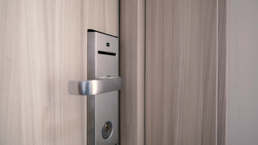 The girl inserts a key card into the door of the hotel room and goes inside Royalty-Free Stock Footage #1042704298