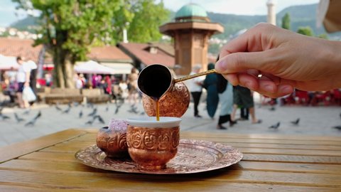 Serving black bosnian coffee with a traditional copper coffee set.  