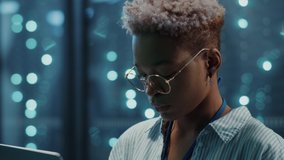 Beautiful african woman IT engineer inspecting a secure server cabinet using modern technology laptop coworking with male technician in data center. - Powered by Shutterstock - Get 15% off with code: PIKWIZARD15
