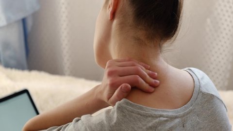 Fibromyalgia concept. Young female feeling discomfort hurt joint pain rubbing, tired teen girl massaging  neck to relieve fibromyalgia ache after long computer study in incorrect posture