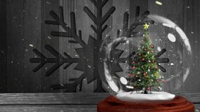 Animation of Christmas snow globe with Christmas tree inside and snow falling with snowflake on wooden boards in the background - Powered by Shutterstock - Get 15% off with code: PIKWIZARD15
