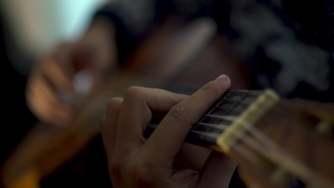Young man plays guitar at home. Plays his new music.