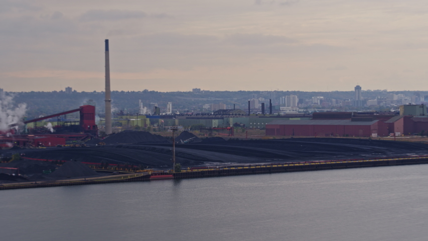 Hamilton Industrial Sector Ontario Aerial Fly by with Industrial Sector in forefront and cityscape in backdrop, from Harbour perspective - October 2017