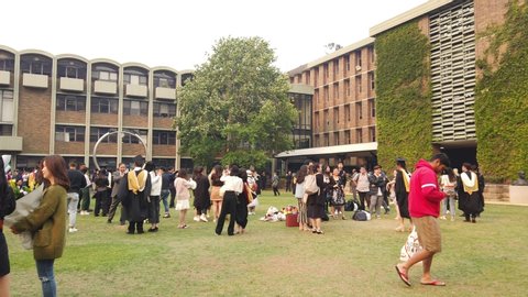 Sydney, NSW / Australia - Dec 02 2019: UNSW University of New South Wales Graduation ceremony. students, friends and family congratulate, take photo in the library lawn in main Kensington campus 