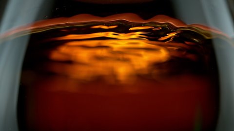 Super Slow Motion Detail Shot of Rippling Whiskey in Glass at 1000fps.