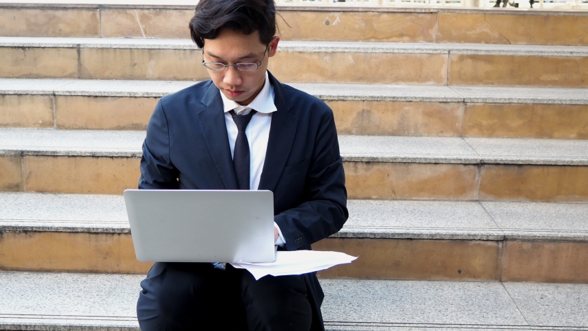 Young Asian business man using computer laptop for his work at outside office. | Shutterstock HD Video #1042729711