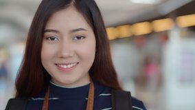 4K handheld video clip with headshot portrait asian pretty girl smiling and looking to camera with shy, copy space