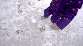 Cute little baby girl playing outdoors in winter snowy beautiful city park. Christmas fun and recreation concept. Slow motion full hd video footage.