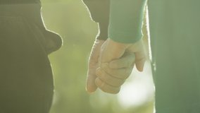 Back view of elderly couple holding hands while walking together in park . Senior couple on a walk in autumn nature. Happiness people lifestyle. Close up of elderly couple hand . Slow motion footage - Powered by Shutterstock - Get 15% off with code: PIKWIZARD15