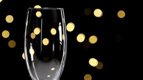champagne in a glass, concept of new year and Christmas champagne pouring in a glass dark background with beautiful yellowbokeh. champagne pour into a glass. Close up shot. Slow motion