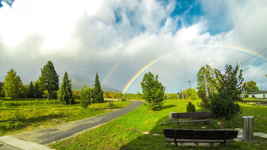 Beautiful rainbow over woods at Vysoke Tatry town in High Tatras mountains, Slovakia. Time Lapse. 4K UltraHD video