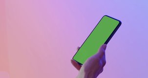 GREEN SCREEN CHROMA KEY CU Caucasian female using modern smart phone, vertical orientation, pastel colors background. 4K UHD RAW Graded footage